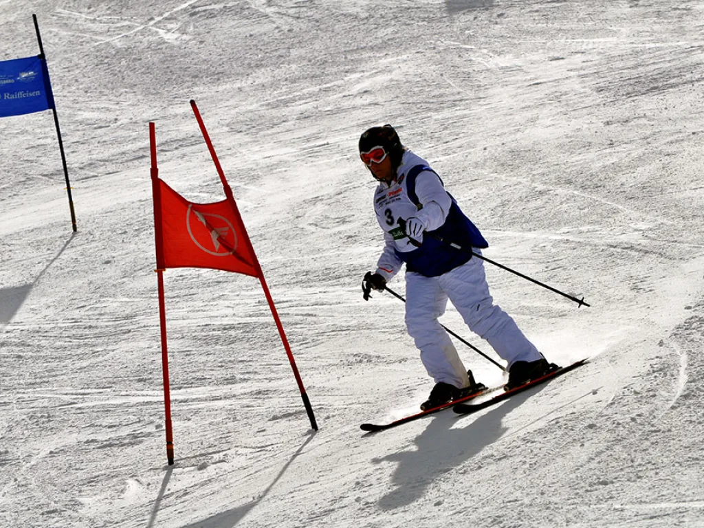 Skifahrerin fährt an einem roten Tor vorbei.